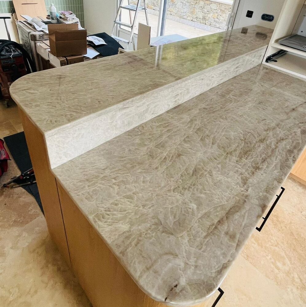 Îlot arrondi en pierre beige texturée